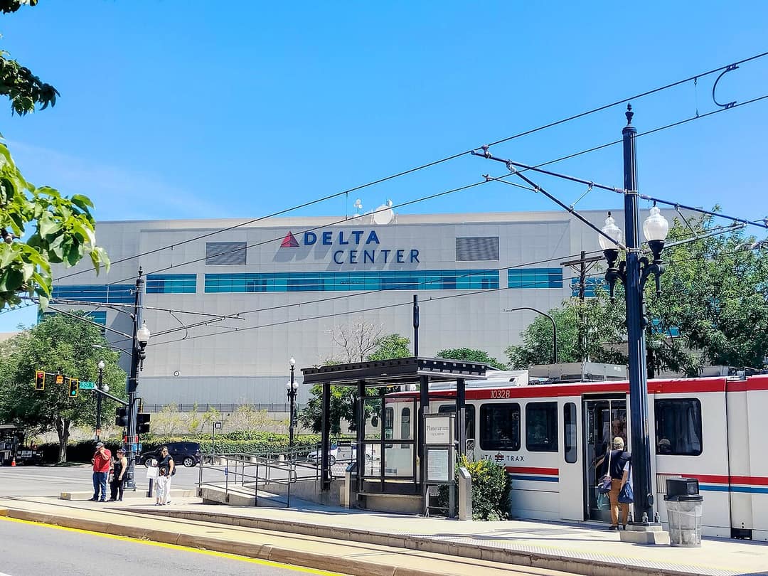 Exterior of the Delta Center in Salt Lake City, Utah, the UFC 332 venue, with a TRAX light-rail stop in front